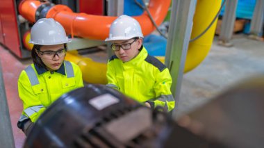 Bir ısıtma tesisinde bakım teknisyeni, Petrokimya işçileri fabrikadaki gaz ve petrol boru hatlarının işleyişini denetliyor, mühendisler işitme koruyucularını birçok boruyla aynı odaya koyuyorlar.