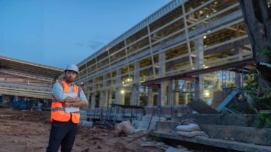 Tayland 'da büyük bir inşaat projesinin şantiyesinde çalışan Asyalı mühendis inşaat alanında fazla mesai yapıyor.