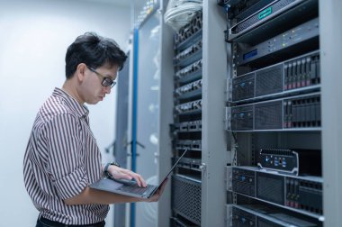 Bilgisayar mühendisi sunucu odasında ağ kuruyor, Sistem Bakım teknisyeni, erkek mühendis modern veri merkezinde sunucu odasında çalışıyor.