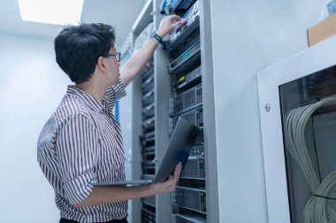 Bilgisayar mühendisi sunucu odasında ağ kuruyor, Sistem Bakım teknisyeni, erkek mühendis modern veri merkezinde sunucu odasında çalışıyor.