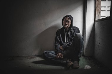 Asyalı bir bağımlı, ıssız bir yerde uyuşturucu bağımlısı, bu dünyada kendini yalnız hisseden bir keş, odanın bir köşesinde oturan üzgün bir genç, insanlar stresli ve depresyondalar.