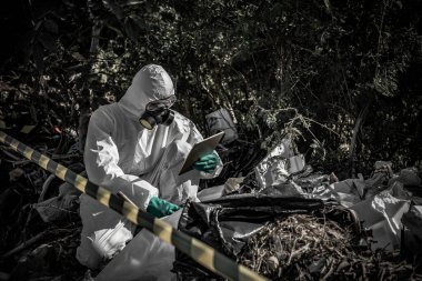 Asyalı bilim adamı Kimyasal koruma giysisi giyiyor. Tehlikeli bölgelerde çalışan tehlikeli kimyasalları kontrol ediyor. Çin 'de ortaya çıkan Corona virüsü soruşturması için örnekler topluyor..