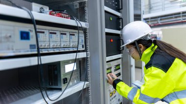 Electrical engineer woman checking voltage at the Power Distribution Cabinet in the control room,preventive maintenance Yearly,Thailand Electrician working at company