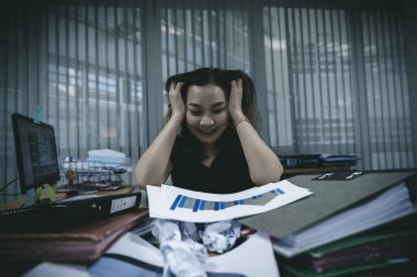 Asyalı ofis kadını iş yoğunluğundan dolayı stresli, çünkü Tayland 'lı genç sekreter yeni projeden yorulduğu için belli bir zamanda iş göndermesi gerektiğini vurguladı.
