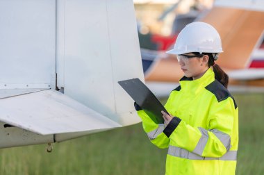 Teknisyen uçağın motorunu tamir ediyor, kadın uzay mühendisliği uçak motorlarını kontrol ediyor, Asyalı tamirci uçak motorlarını kontrol ediyor.