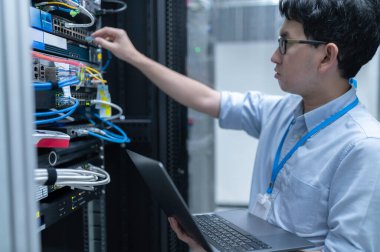 Bilgisayar mühendisi sunucu odasında ağ kuruyor, Sistem Bakım teknisyeni, erkek mühendis modern veri merkezinde sunucu odasında çalışıyor.