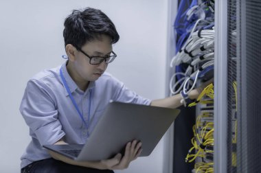 Bilgisayar mühendisi sunucu odasında ağ kuruyor, Sistem Bakım teknisyeni, erkek mühendis modern veri merkezinde sunucu odasında çalışıyor.