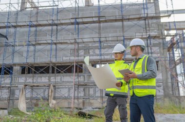 Büyük bir inşaat projesinin şantiyesinde çalışan iki Asyalı mühendis inşaat alanında fazla mesai, inşaat alanındaki mühendis diski, mimar, yönetici ve ustabaşı tasarımı tartışmak için bir araya geldiler.