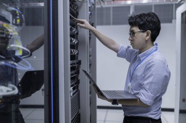 Bilgisayar mühendisi sunucu odasında ağ kuruyor, Sistem Bakım teknisyeni, erkek mühendis modern veri merkezinde sunucu odasında çalışıyor.