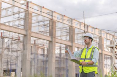 Büyük bir inşaat projesinin şantiyesinde çalışan iki Asyalı mühendis inşaat alanında fazla mesai, inşaat alanındaki mühendis diski, mimar, yönetici ve ustabaşı tasarımı tartışmak için bir araya geldiler.