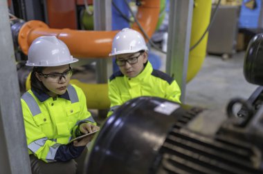 Bir ısıtma tesisinde bakım teknisyeni, Petrokimya işçileri fabrikadaki gaz ve petrol boru hatlarının işleyişini denetliyor, mühendisler işitme koruyucularını birçok boruyla aynı odaya koyuyorlar.