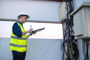 Telekomünikasyon mühendisleri 5G cep telefonu sinyalleri için baz istasyonlarında çalışıyorlar.