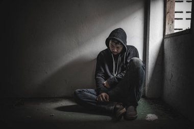 Asyalı bir bağımlı, ıssız bir yerde uyuşturucu bağımlısı, bu dünyada kendini yalnız hisseden bir keş, odanın bir köşesinde oturan üzgün bir genç, insanlar stresli ve depresyondalar.