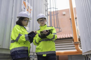 Bir ısıtma tesisinde bakım teknisyeni, Petrokimya işçileri fabrikadaki gaz ve petrol boru hatlarının işleyişini denetliyor, mühendisler işitme koruyucularını birçok boruyla aynı odaya koyuyorlar.