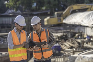 Nehir kıyısındaki bir köprü inşaatında inşaat mühendisi inşaat mühendisi, inşaat denetçisi, Foreman inşaat sahasında çalışıyor, teknik sorunları birlikte tartışıyorlar.