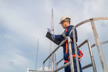 Yüksek Riskli Taşımacılık Tesisinde İletişim Sinyallerini ve Endüstriyel Makineleri İncelemek İçin Bir Merdiven Tırmanıyor