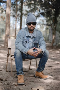 Fasulye, güneş gözlüğü, Denim giysisi ve botlar giyen şık bir Asyalı, kendine güven ve modern moda, Kentsel stilde mükemmel harmanlayan serinlik ve zarafet