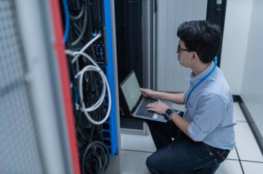 Bilgisayar mühendisi sunucu odasında ağ kuruyor, Sistem Bakım teknisyeni, erkek mühendis modern veri merkezinde sunucu odasında çalışıyor.