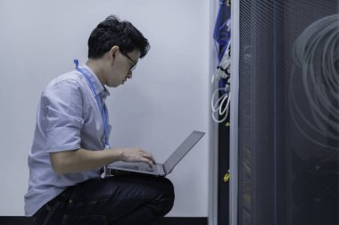 Bilgisayar mühendisi sunucu odasında ağ kuruyor, Sistem Bakım teknisyeni, erkek mühendis modern veri merkezinde sunucu odasında çalışıyor.