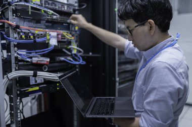 Bilgisayar mühendisi sunucu odasında ağ kuruyor, Sistem Bakım teknisyeni, erkek mühendis modern veri merkezinde sunucu odasında çalışıyor.