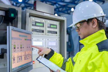 Electrical engineer woman checking voltage at the Power Distribution Cabinet in the control room,preventive maintenance Yearly,Thailand Electrician working at company