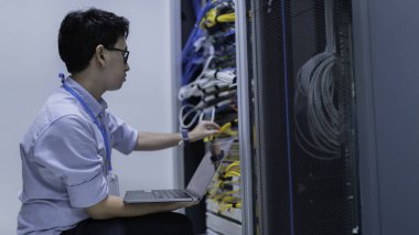 Bilgisayar mühendisi sunucu odasında ağ kuruyor, Sistem Bakım teknisyeni, erkek mühendis modern veri merkezinde sunucu odasında çalışıyor.