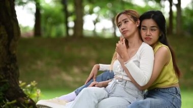 Asyalı genç lgbt çifti parkta dinleniyor.