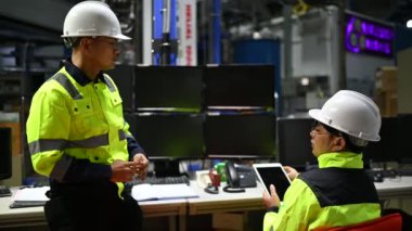 Üniformalı mühendisler ve fabrikada çalışan güvenlik ekipmanları endüstriyel mühendislik konsepti, çalışma sürecini tartışan erkekler.