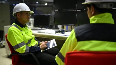 Üniformalı mühendisler ve fabrikada çalışan güvenlik ekipmanları endüstriyel mühendislik konsepti, çalışma sürecini tartışan erkekler.