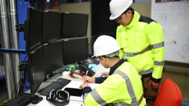 Üniformalı mühendisler ve fabrikada çalışan güvenlik ekipmanları endüstriyel mühendislik konsepti, çalışma sürecini tartışan erkekler.