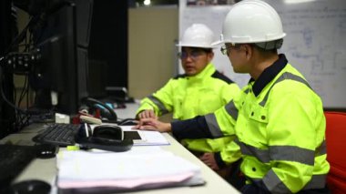 Üniformalı mühendisler ve fabrikada çalışan güvenlik ekipmanları endüstriyel mühendislik konsepti, çalışma sürecini tartışan erkekler.