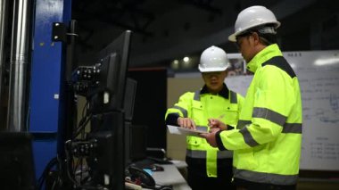 Üniformalı mühendisler ve fabrikada çalışan güvenlik ekipmanları endüstriyel mühendislik konsepti, çalışma sürecini tartışan erkekler.