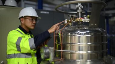 Ameliyathanedeki Asyalı mühendis özen ve sabırla çalıştı. Hidrojen tankındaki valf düzenleyicisini kontrol etti..