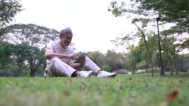 Parktaki çimlerde dijital tablet kullanan adam