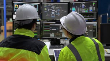 Büyük Endüstri Fabrikası Erkek Bilgisayar Mühendisleri Kişisel Bilgisayarlar üzerinde çalışıyor kontrol makinesi için kodlama programı, Taylandlılar dört monitör ve ciddi bir programcıyla çalışıyorlar.