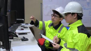 Büyük Endüstri Fabrikası Erkek Bilgisayar Mühendisleri Kişisel Bilgisayarlar üzerinde çalışıyor kontrol makinesi için kodlama programı, Taylandlılar dört monitör ve ciddi bir programcıyla çalışıyorlar.