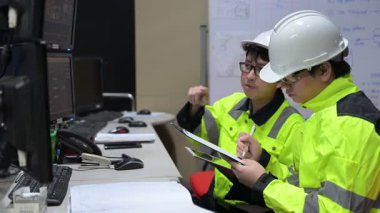 Büyük Endüstri Fabrikası Erkek Bilgisayar Mühendisleri Kişisel Bilgisayarlar üzerinde çalışıyor kontrol makinesi için kodlama programı, Taylandlılar dört monitör ve ciddi bir programcıyla çalışıyorlar.