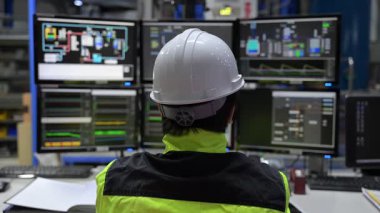 Kontrol odasında çalışan mühendis büyük sanayi tesislerinde, yönetici kontrol sisteminde, birçok monitörden teknisyen izleme programında, konsept endüstrisinde.