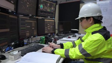 Kontrol odasında çalışan mühendis büyük sanayi tesislerinde, yönetici kontrol sisteminde, birçok monitörden teknisyen izleme programında, konsept endüstrisinde.