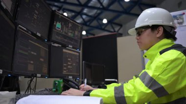 Kontrol odasında çalışan mühendis büyük sanayi tesislerinde, yönetici kontrol sisteminde, birçok monitörden teknisyen izleme programında, konsept endüstrisinde.