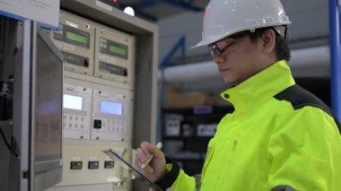 Kontrol odasında çalışan mühendis, yönetici kontrol sistemi, monitörden teknisyen izleme programı.