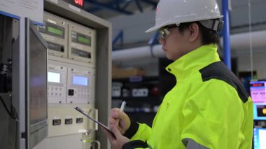 Kontrol odasında çalışan mühendis, yönetici kontrol sistemi, monitörden teknisyen izleme programı.