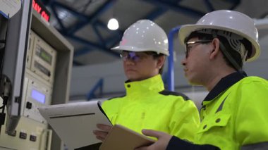 Büyük Endüstri Fabrikası Erkek Bilgisayar Mühendisleri Kişisel Bilgisayarlar üzerinde çalışıyor kontrol makinesi için kodlama programı, Taylandlılar dört monitör ve ciddi bir programcıyla çalışıyorlar.