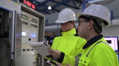 Büyük Endüstri Fabrikası Erkek Bilgisayar Mühendisleri Kişisel Bilgisayarlar üzerinde çalışıyor kontrol makinesi için kodlama programı, Taylandlılar dört monitör ve ciddi bir programcıyla çalışıyorlar.