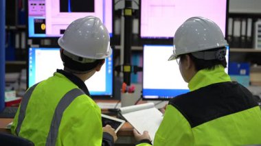 Büyük Endüstri Fabrikası Erkek Bilgisayar Mühendisleri Kişisel Bilgisayarlar üzerinde çalışıyor kontrol makinesi için kodlama programı, Taylandlılar dört monitör ve ciddi bir programcıyla çalışıyorlar.