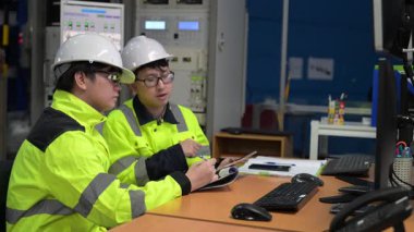 Büyük Endüstri Fabrikası Erkek Bilgisayar Mühendisleri Kişisel Bilgisayarlar üzerinde çalışıyor kontrol makinesi için kodlama programı, Taylandlılar dört monitör ve ciddi bir programcıyla çalışıyorlar.