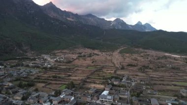 Baisha Antik Kasabası 'nın tepesinde vadi ve tarlalarla dolu bir video. Dağlar ufku kucaklıyor 