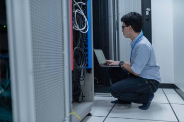 Bilgisayar mühendisi sunucu odasında ağ kuruyor, Sistem Bakım teknisyeni, erkek mühendis modern veri merkezinde sunucu odasında çalışıyor.