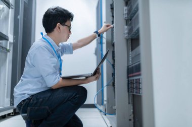 Bilgisayar mühendisi sunucu odasında ağ kuruyor, Sistem Bakım teknisyeni, erkek mühendis modern veri merkezinde sunucu odasında çalışıyor.