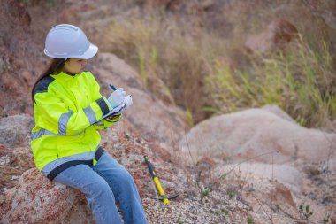 Benimkini inceleyen jeolog, kaşifler mineralleri aramak, dünyanın derinliklerini araştırmak, kaya oluşumlarını analiz etmek için toprak örnekleri topluyor.